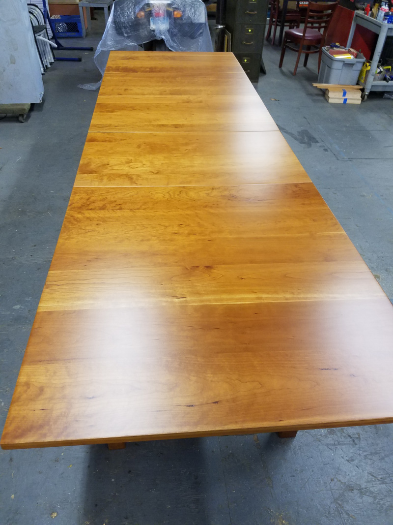 Refinished wooden long dining room table.